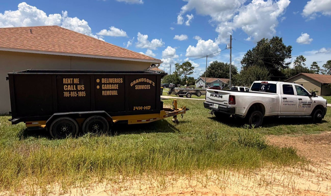 Grandson's Services truck and dump trailer picking up junk at a home